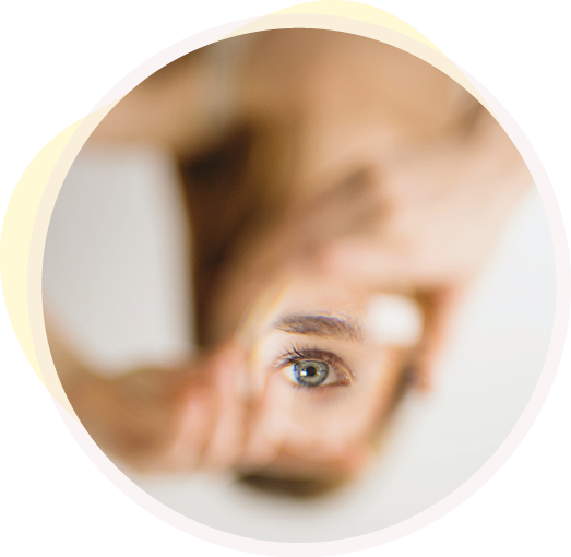 Ein Auge spiegelt sich in einem kleinen Handspiegel und steht im Fokus des Bildes.